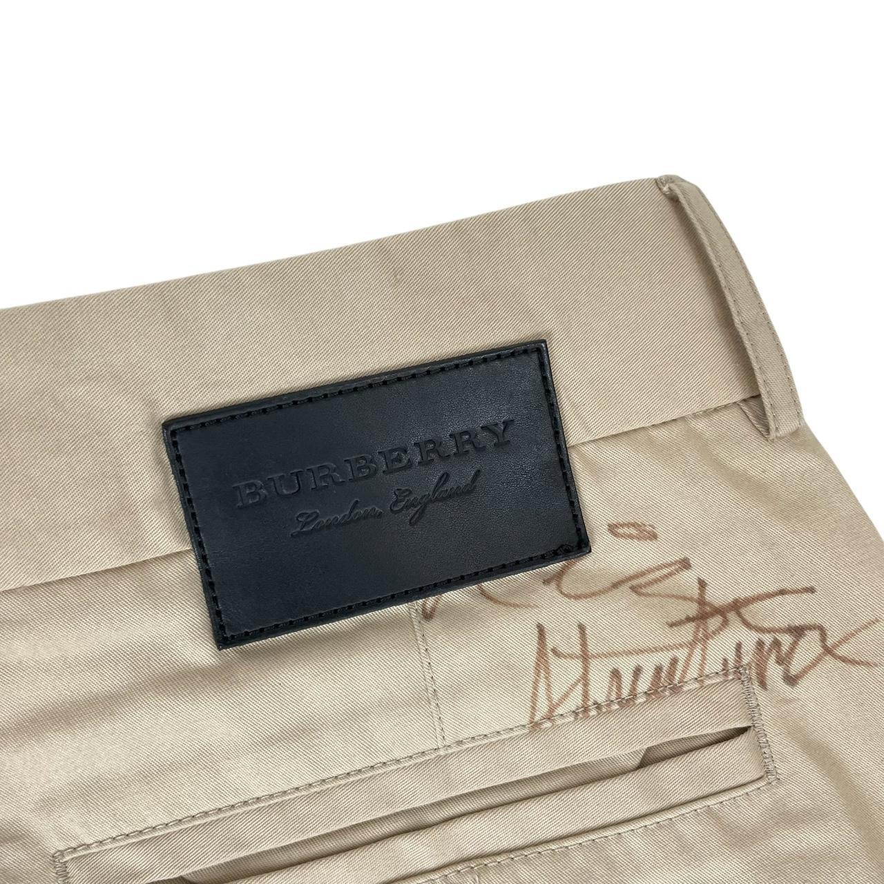 Burberry beige tapered fit trousers with sketch print design and cotton material.