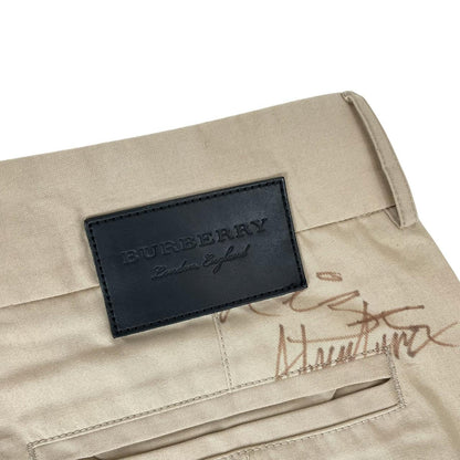 Burberry beige tapered fit trousers with sketch print design and cotton material.