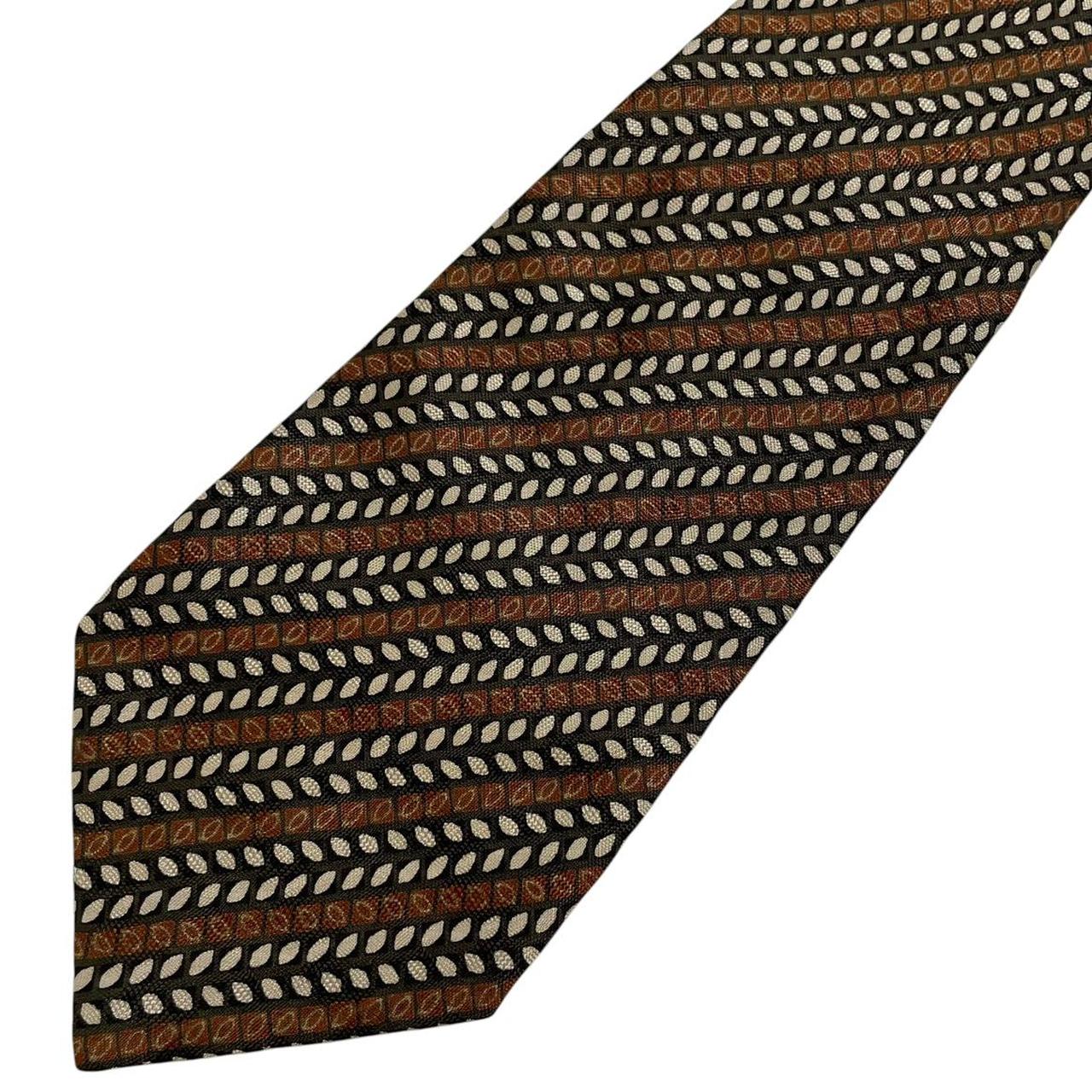 Coach brown floral print silk tie with intricate flower patterns and smooth texture.