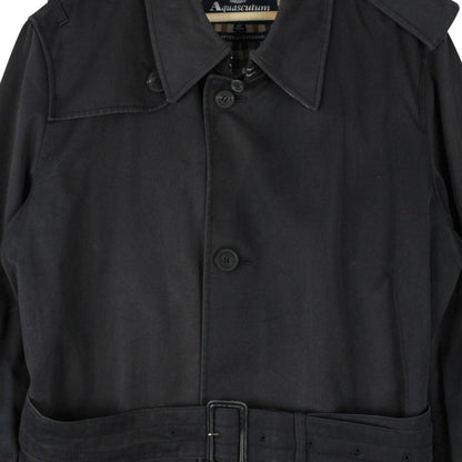 Aquascutum black trench coat with house check pattern and belted waist detail.