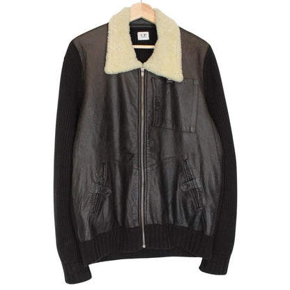 CP Company brown leather and wool shearling jacket with vintage design and logo details.