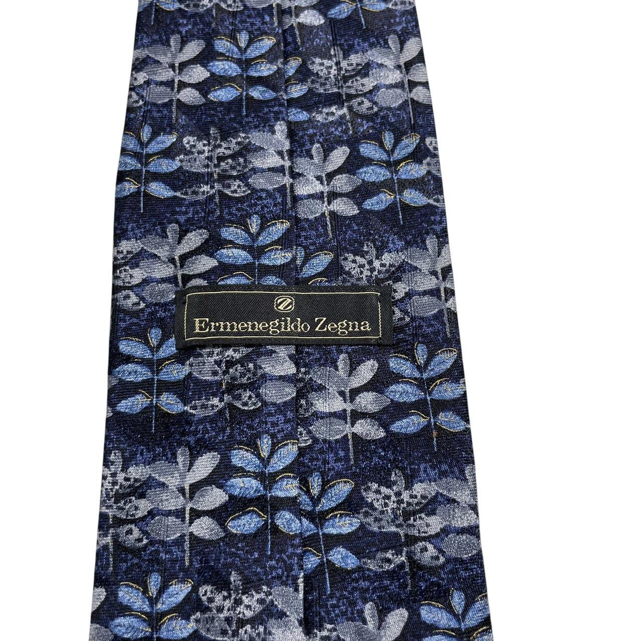 Ermenegildo Zegna blue silk tie with floral print design and logo detail.