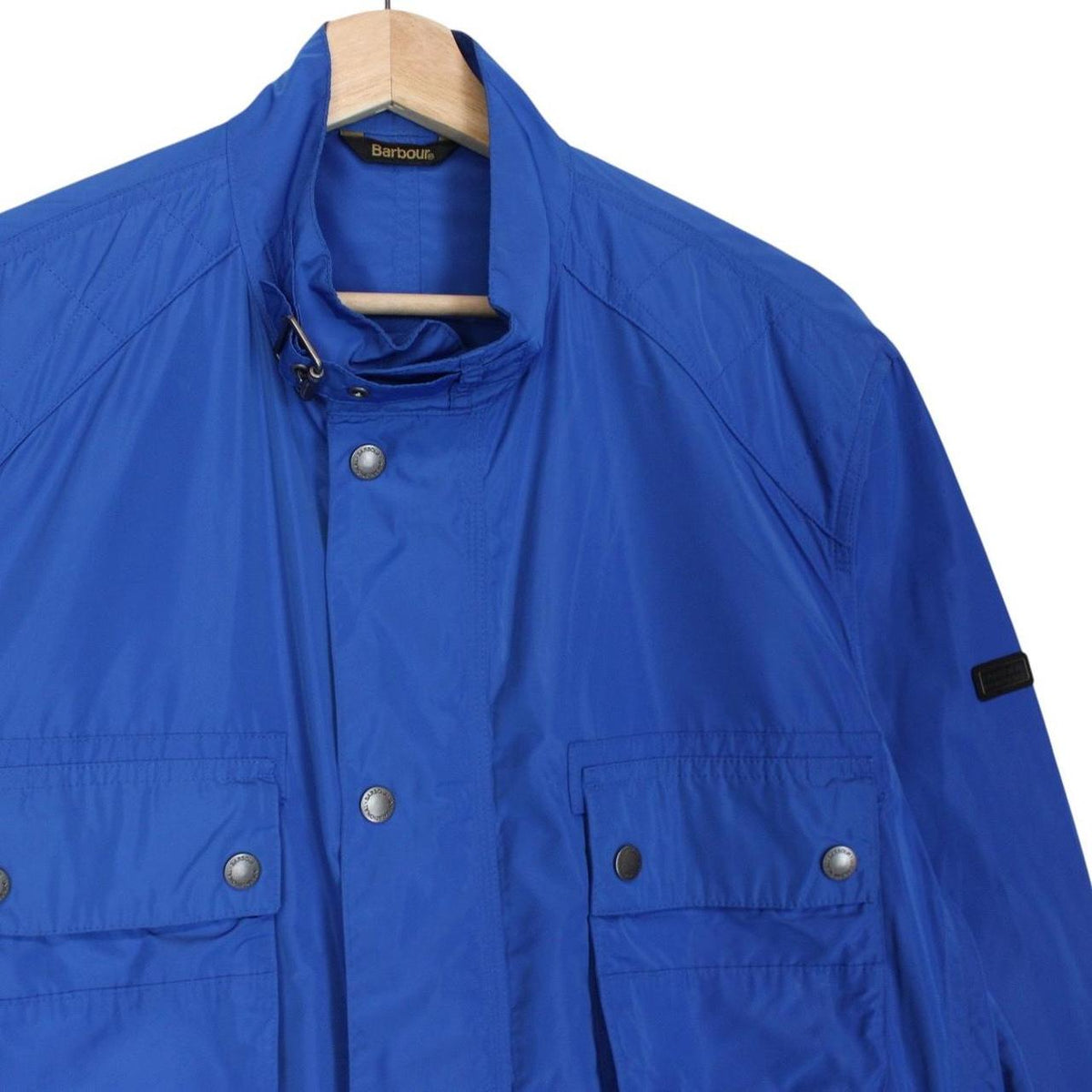 Barbour blue nylon multi-pocket jacket with logo detailing and scuff on bottom right pocket.