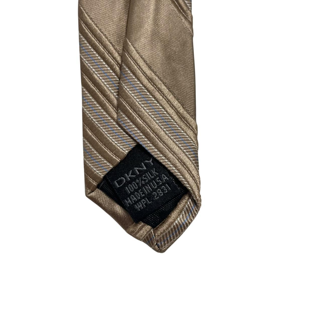 DKNY gold silk tie with vertical stripes and logo detail.