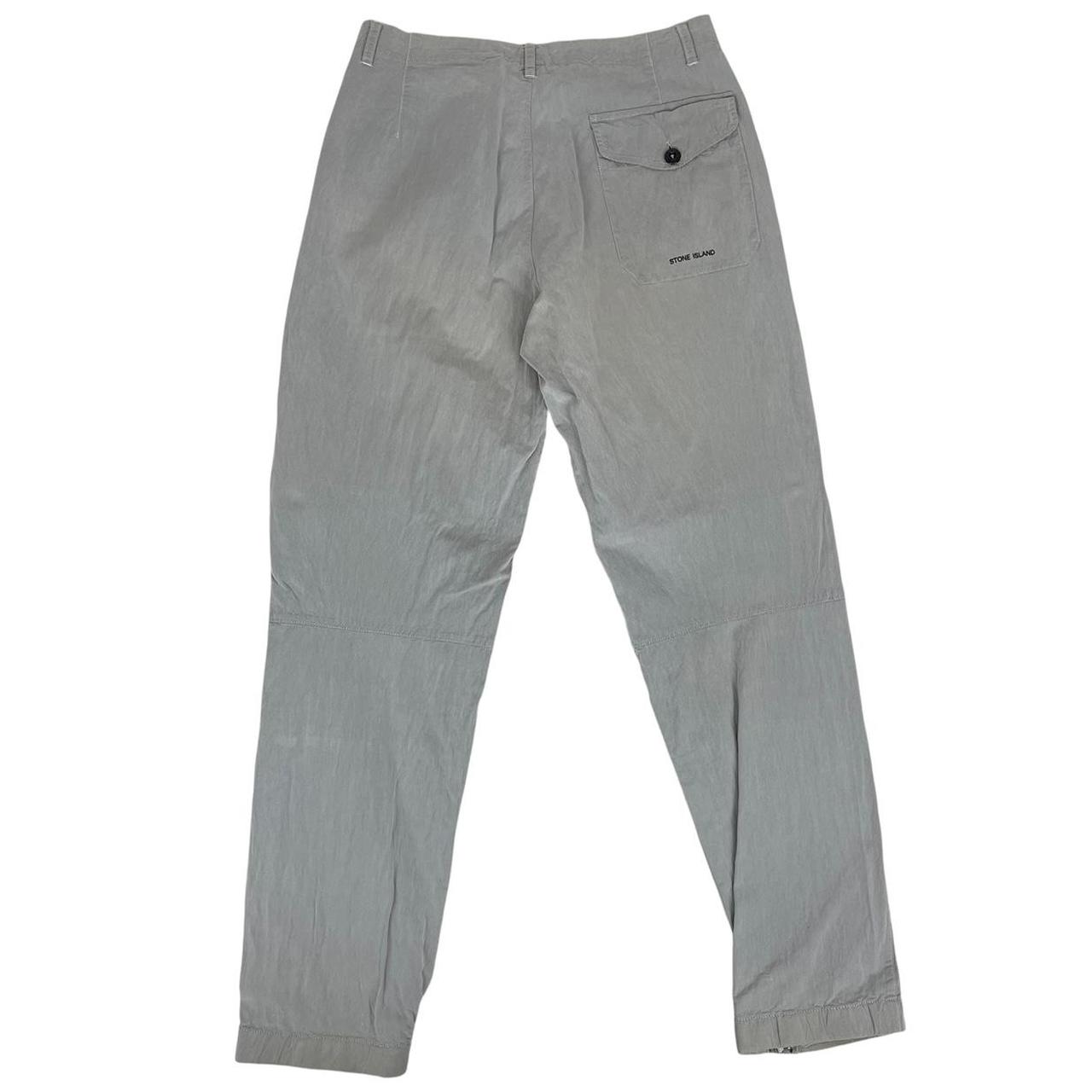 Stone Island grey tapered fit trousers with logo patch and cotton material.