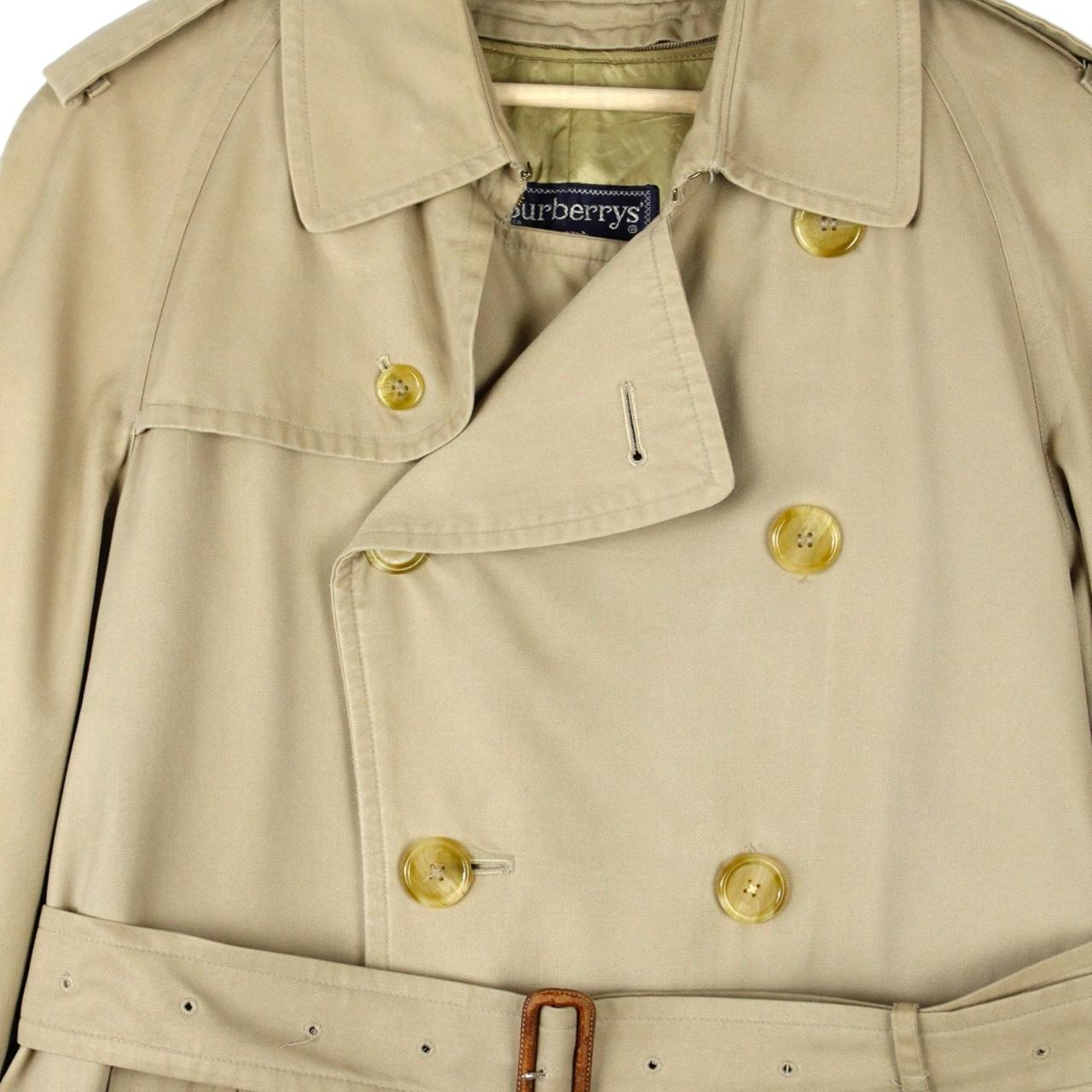 Burberry beige trench coat with Nova Check pattern, double-breasted and belted design.