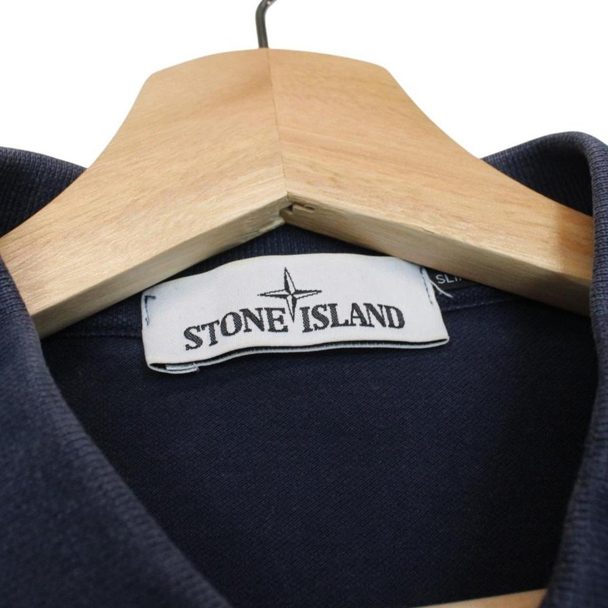 Stone Island navy blue polo shirt with embroidered compass logo and cotton material.