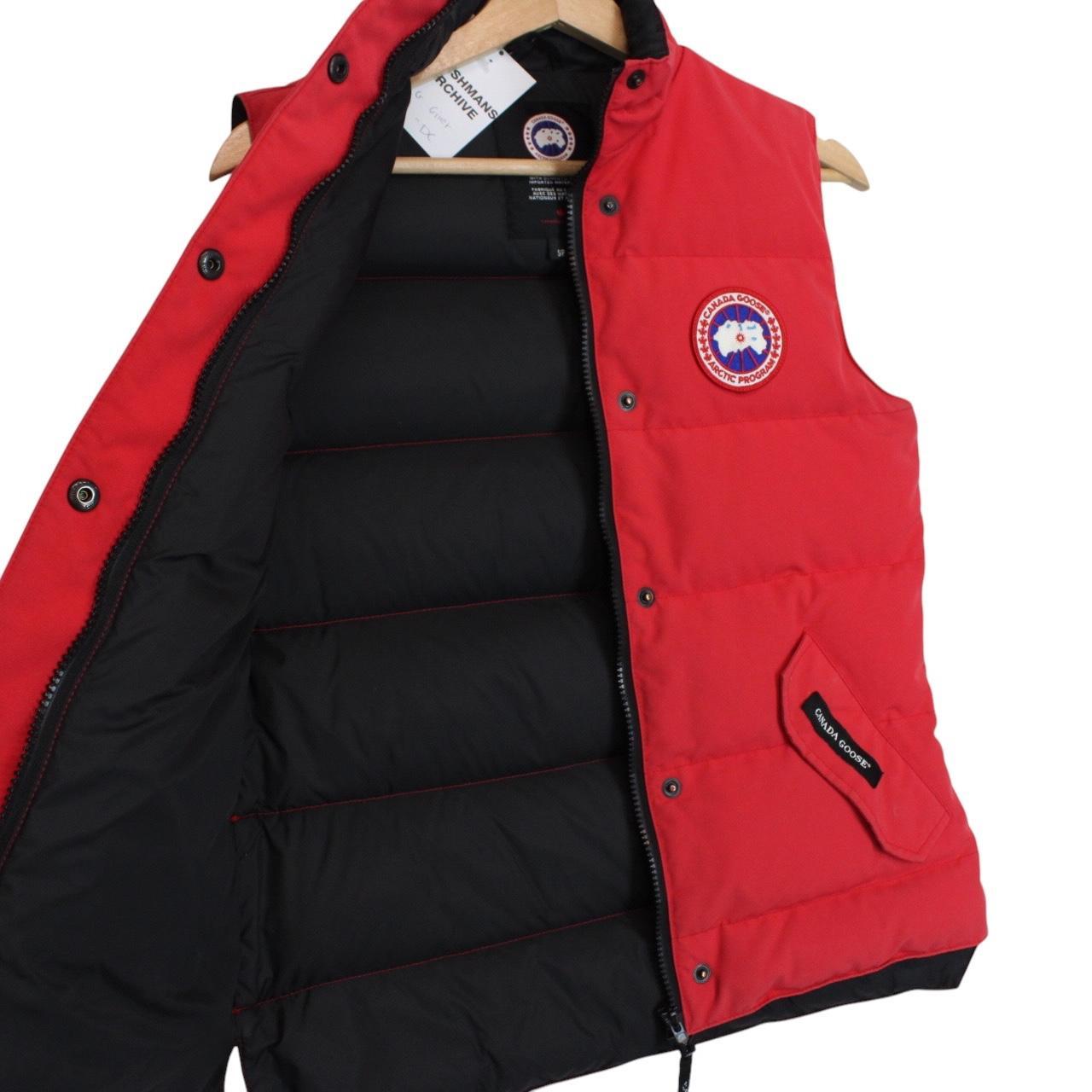 Canada Goose red down gilet with logo patch and zippered pockets.