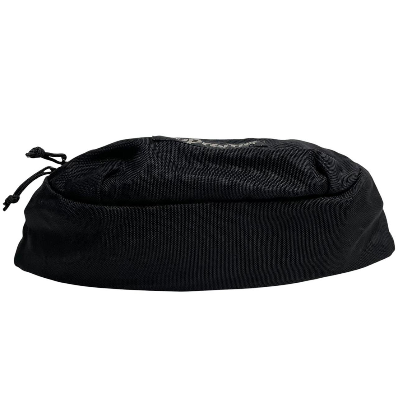 Supreme black waist bag featuring logo print and durable material.