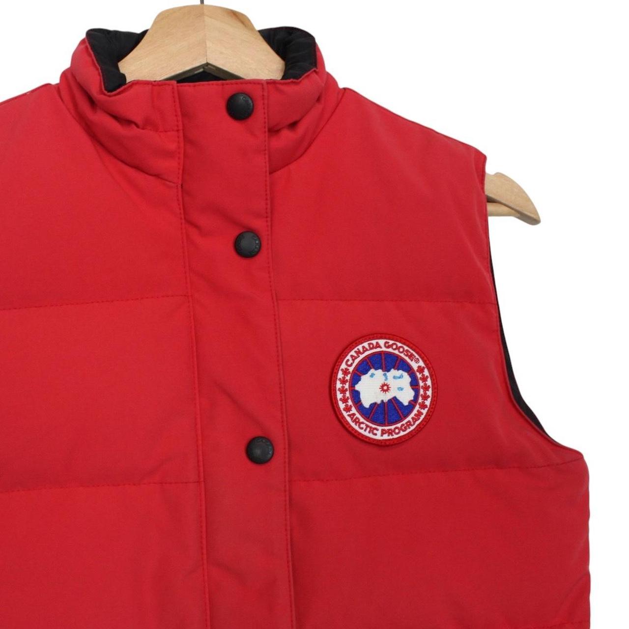 Canada Goose red down gilet with logo patch and zippered pockets.