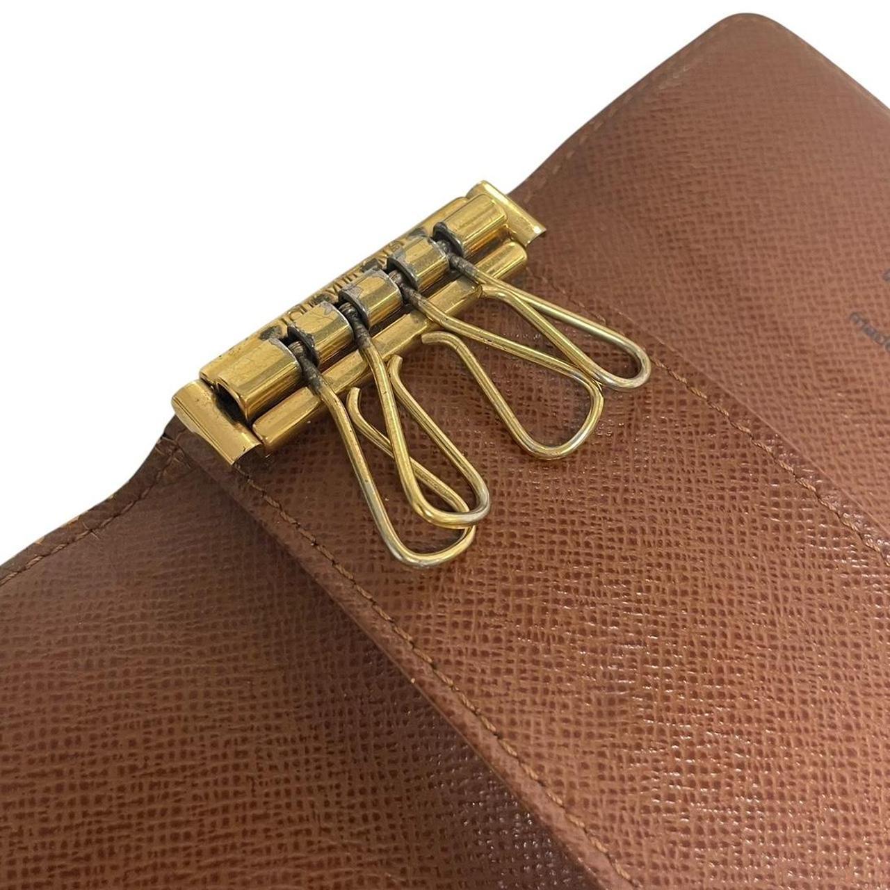 Louis Vuitton brown and tan monogram canvas key case with logo detail.