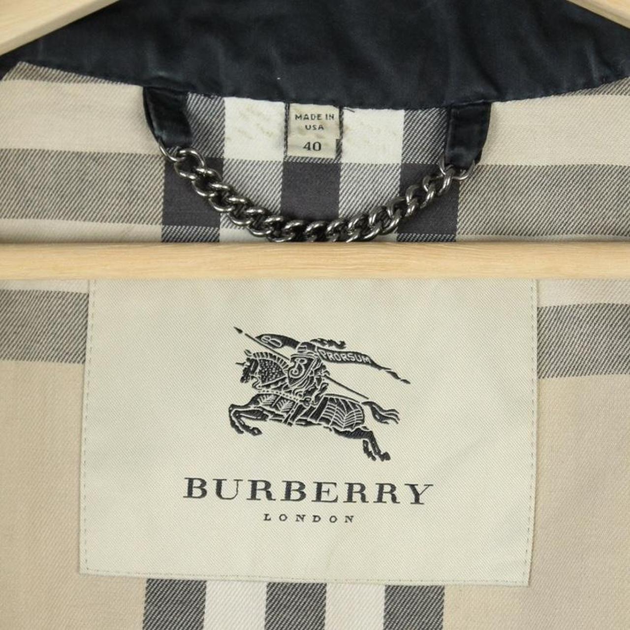 Burberry beige double breasted belted trench coat with classic check lining and logo detail.