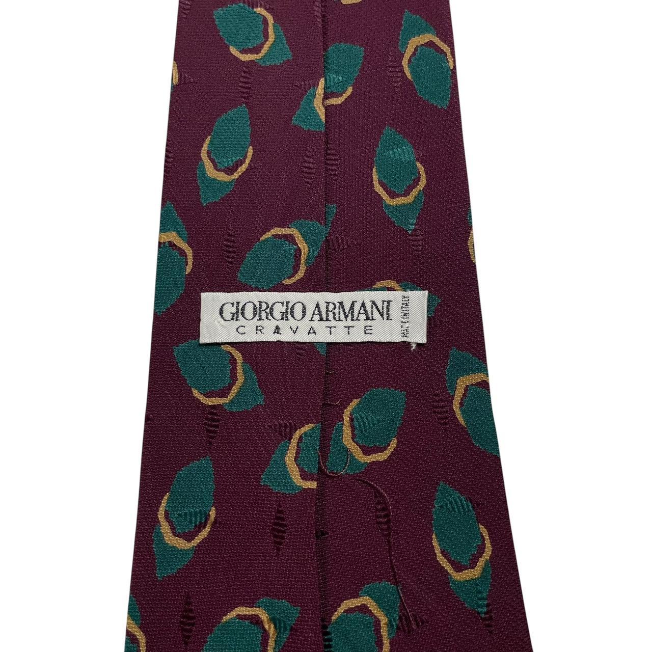 Giorgio Armani burgundy silk tie with geometric print and logo detail.