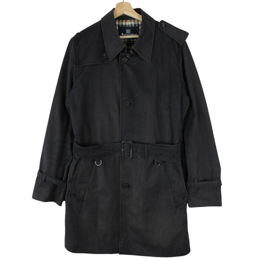 Aquascutum black trench coat with house check pattern and belted waist detail.