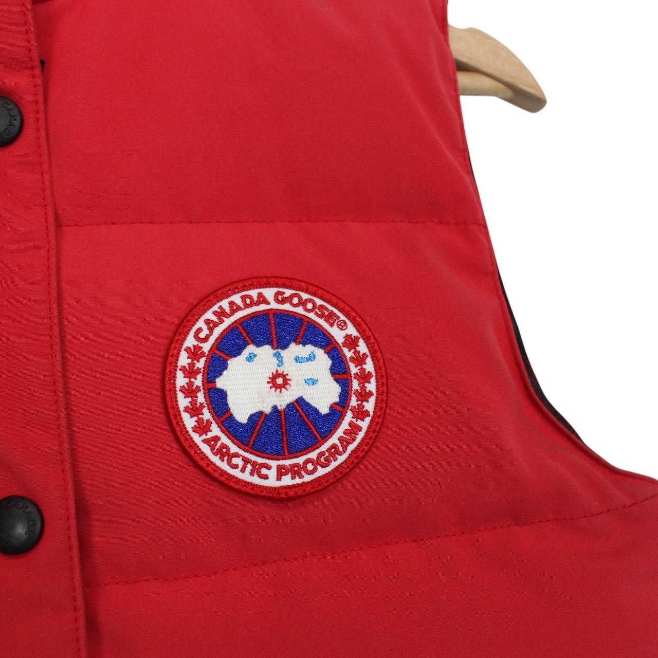 Canada Goose red down gilet with logo patch and zippered pockets.