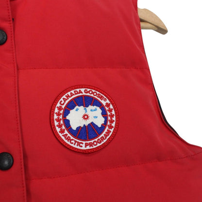 Canada Goose red down gilet with logo patch and zippered pockets.
