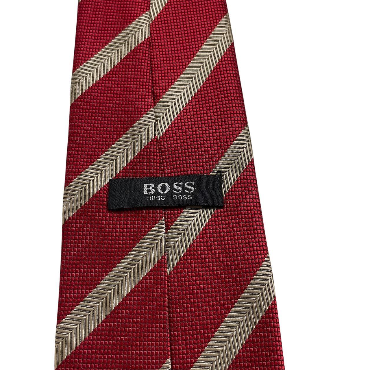Hugo Boss red striped silk tie with subtle sheen and classic design.