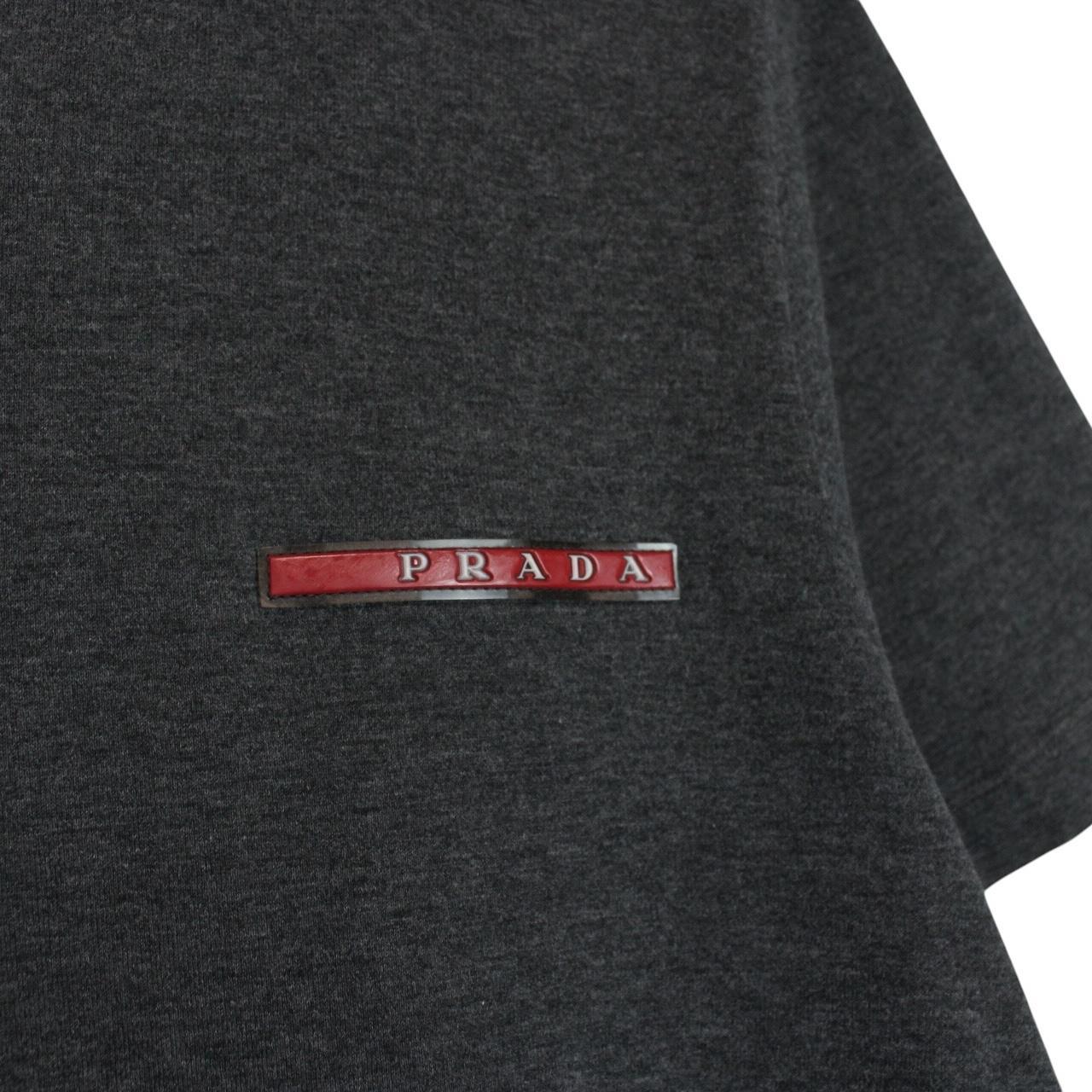 Prada grey cotton t-shirt with red logo and pocket detail, vintage style.