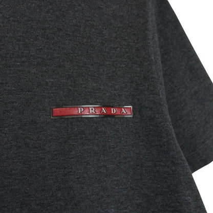 Prada grey cotton t-shirt with red logo and pocket detail, vintage style.
