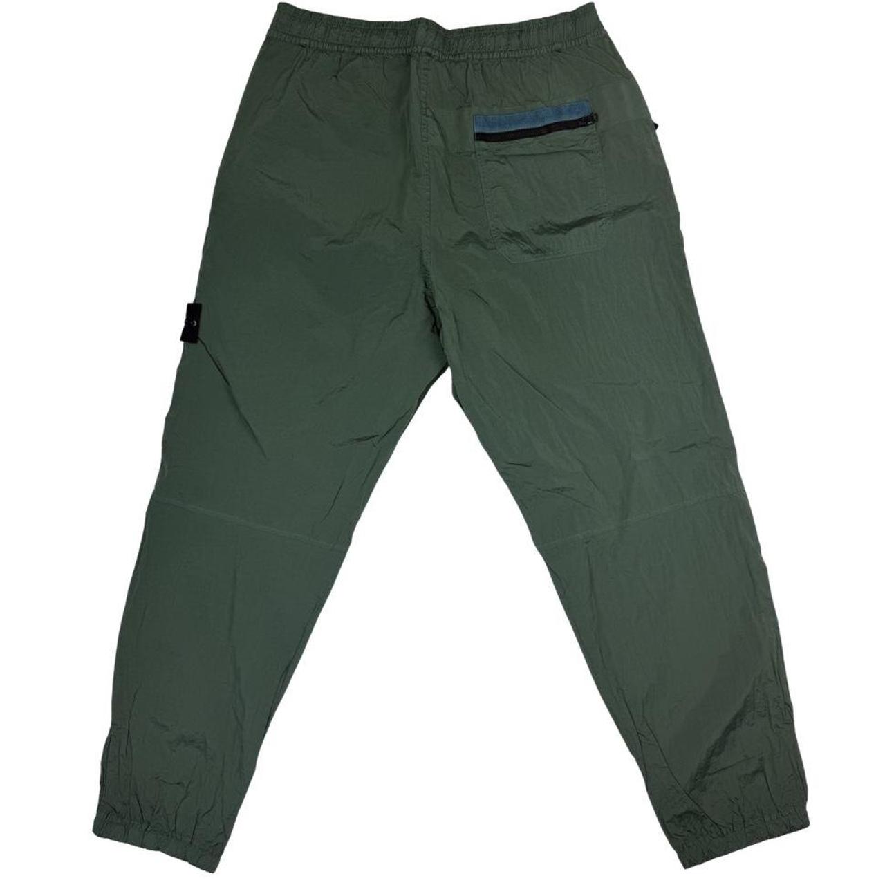 Stone Island green nylon metal trousers with logo patch and sleek finish.