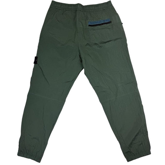 Stone Island green nylon metal trousers with logo patch and sleek finish.