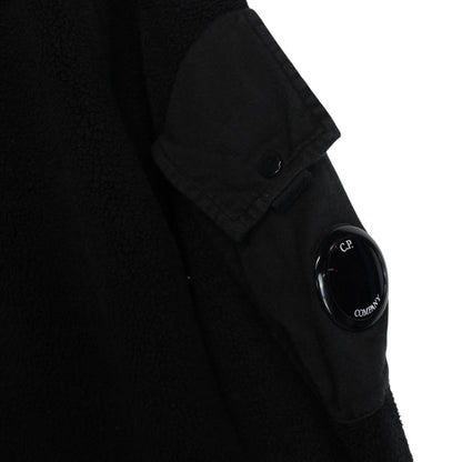 CP Company black fleece jumper with raglan sleeves and iconic lens detail.
