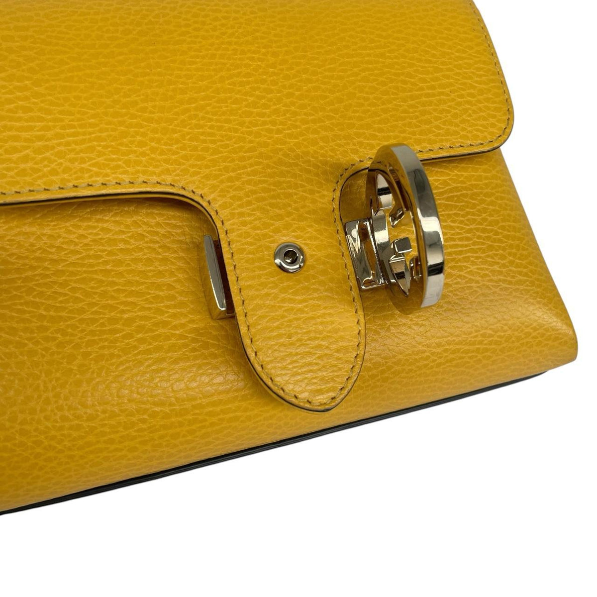 Gucci yellow leather crossbody bag with interlocking G logo and minor metal scratches.