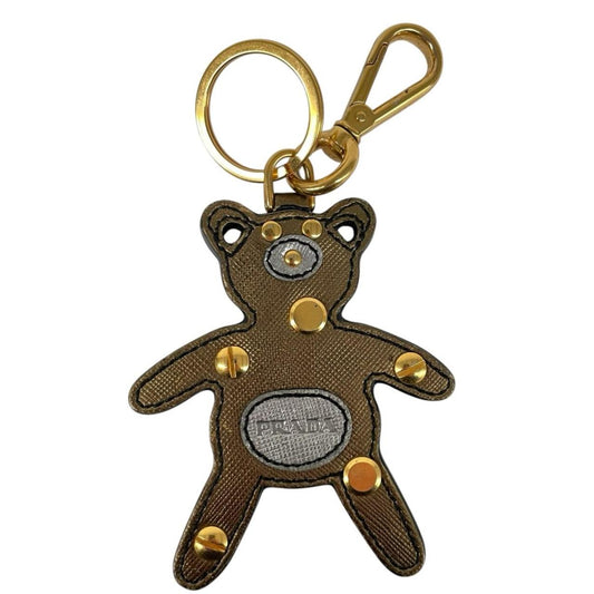 Prada brown and gold teddy bear bag charm in Saffiano leather with logo detail.