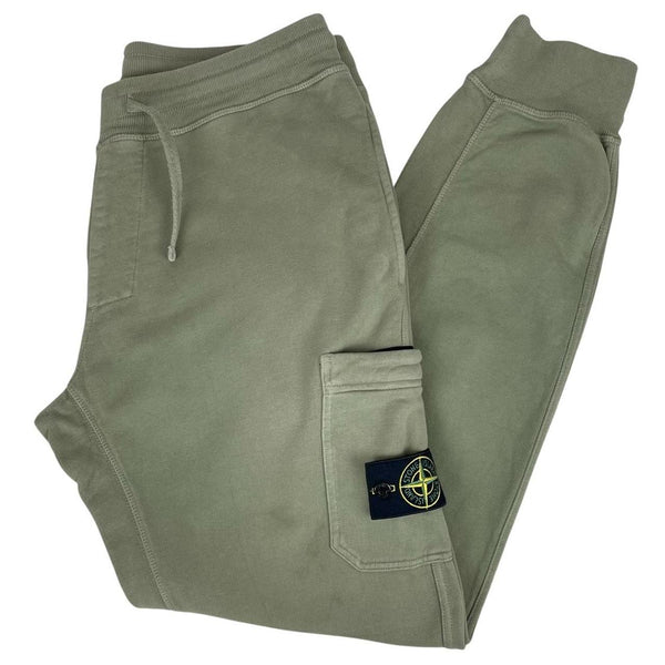 Stone Island green joggers with logo patch and cotton material, visible wear marks.