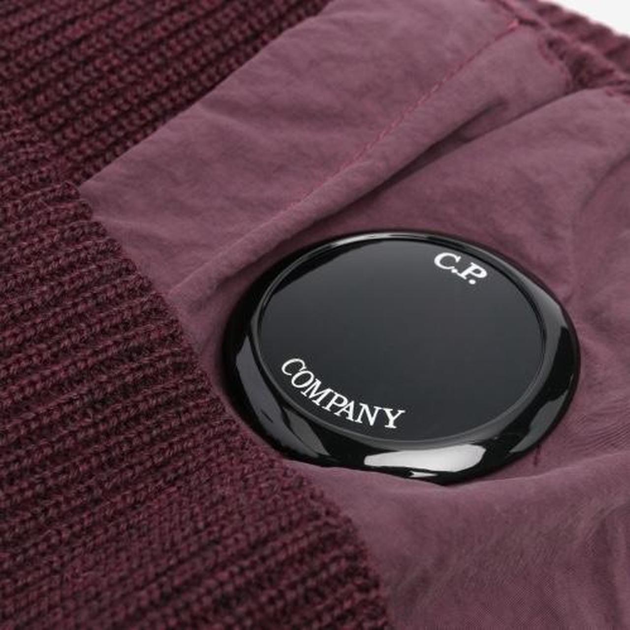 CP Company burgundy beanie hat extra fine merino wool with iconic lens detail.