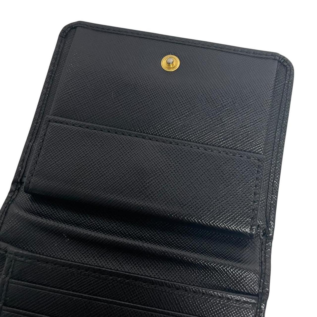 Prada black bifold wallet Saffiano leather with logo embossed detail.