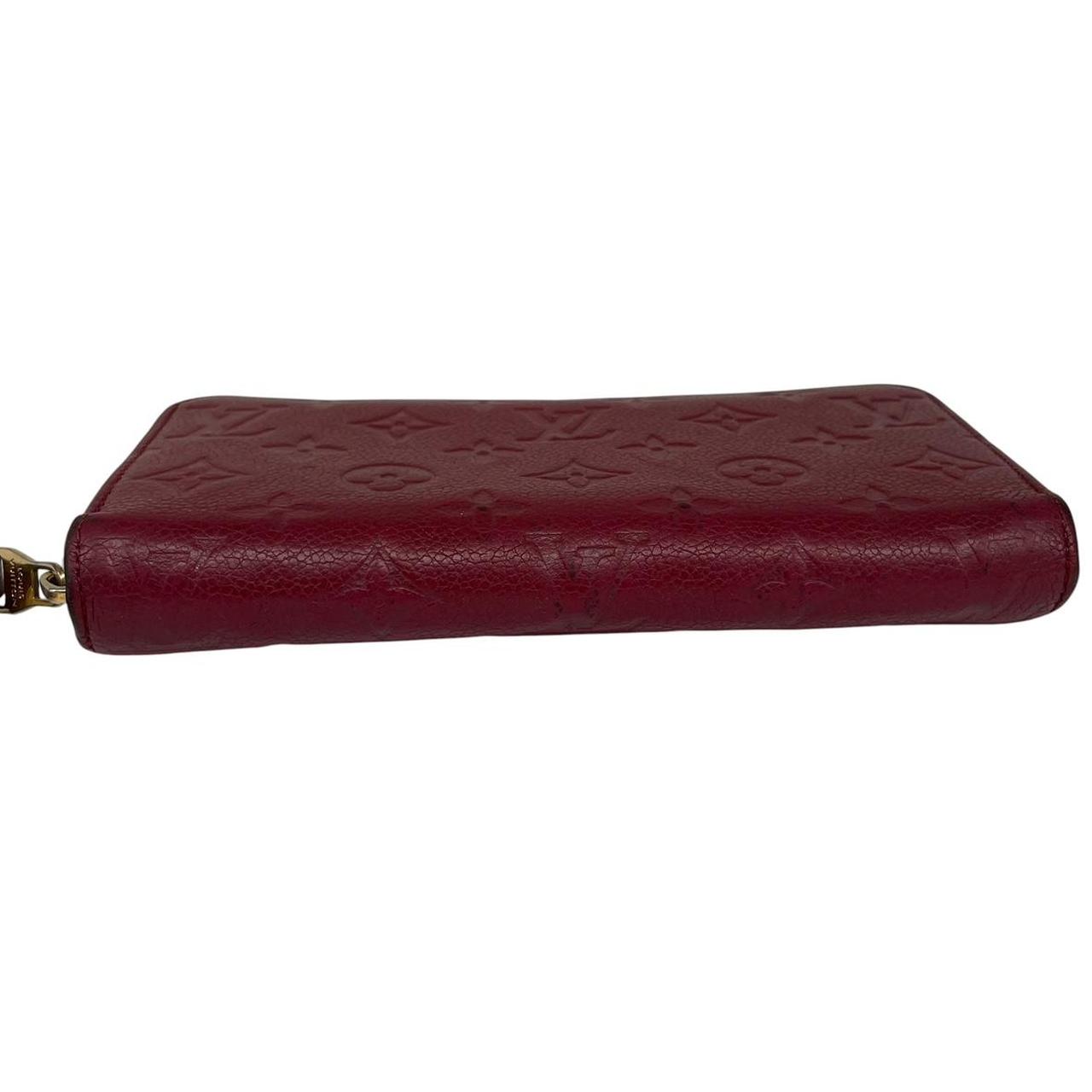 Louis Vuitton black leather wallet with monogram pattern and embossed logo.