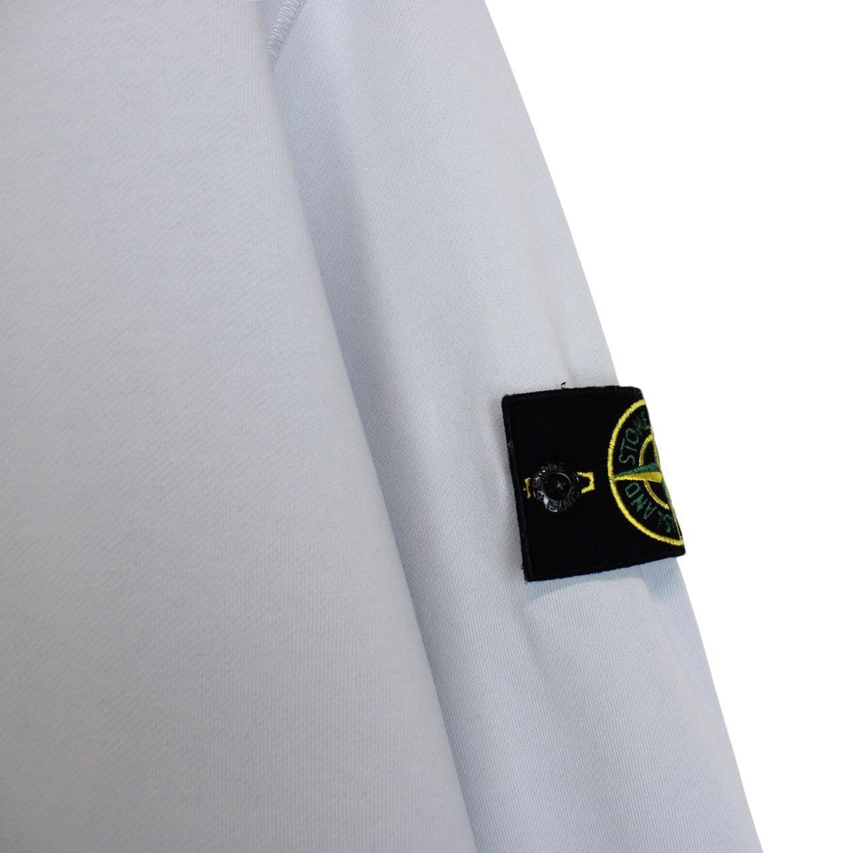 Stone Island blue cotton sweatshirt with logo patch and faded left sleeve.