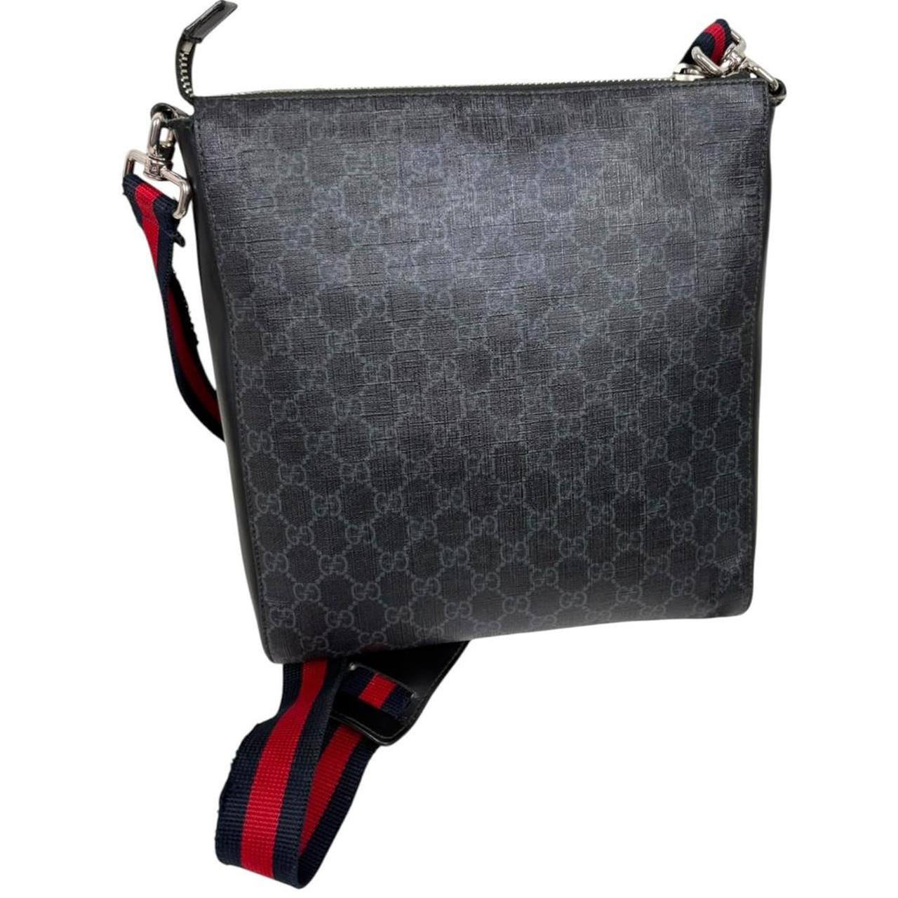 Gucci black duffel bag featuring GG Supreme monogram pattern and adjustable strap.