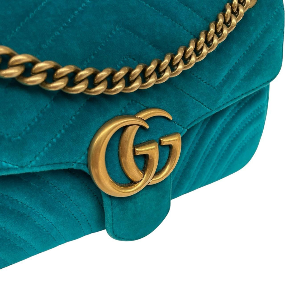 Gucci turquoise velvet shoulder bag with gold GG logo and green accents.