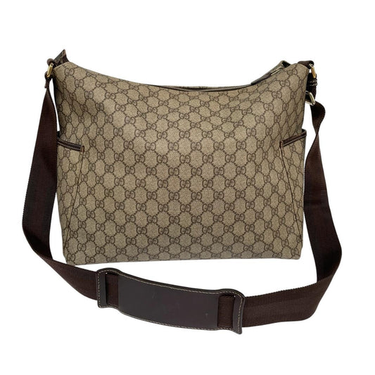 Gucci brown diaper changing bag with Supreme GG monogram and leather shoulder strap.