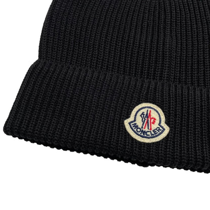Moncler black ribbed knit beanie hat with embroidered logo detail.