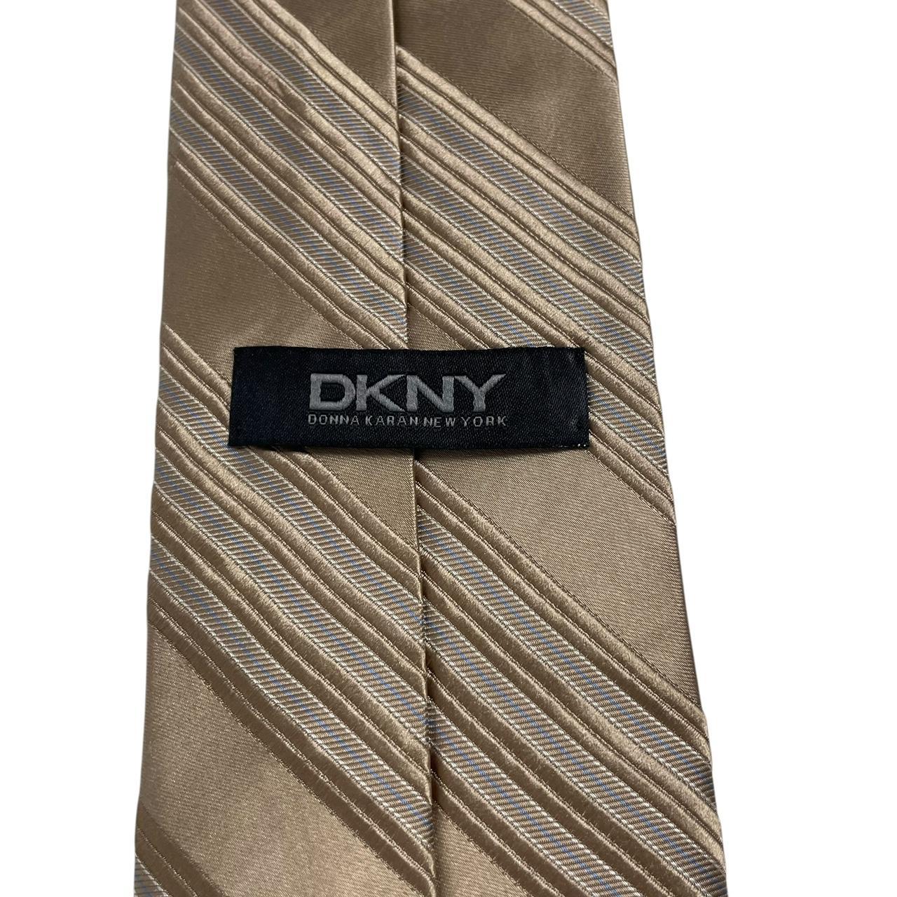 DKNY gold silk tie with vertical stripes and logo detail.