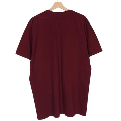Stüssy burgundy pocket t-shirt with yellow college print and faint shoulder mark.