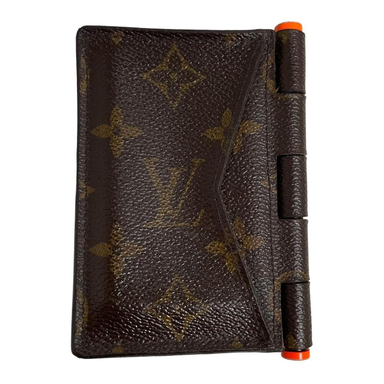Louis Vuitton brown purse with orange metal hardware and iconic monogram pattern.