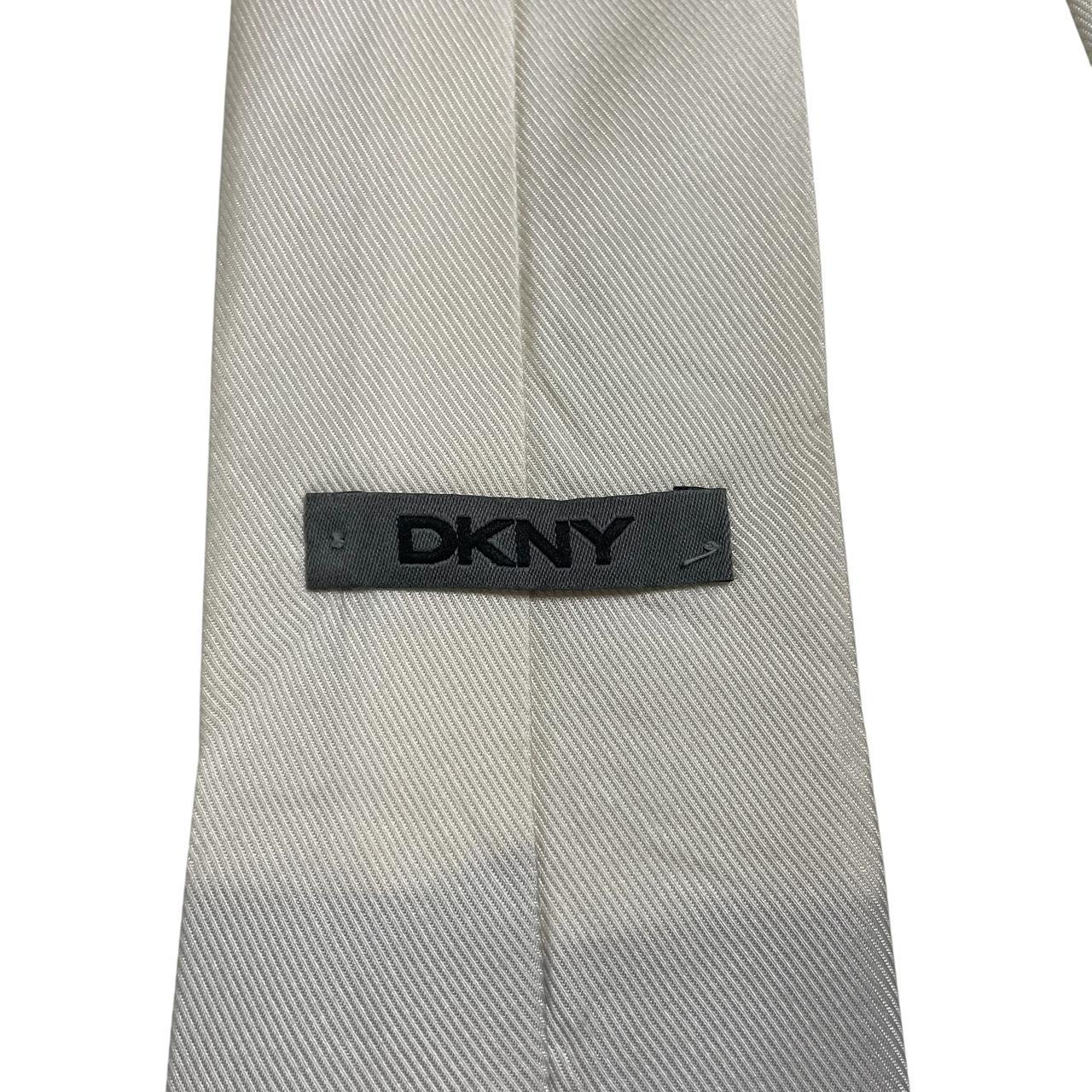 DKNY white silk tie with smooth texture and classic design.