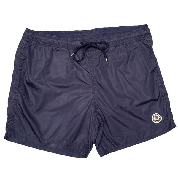 Moncler navy blue swim shorts with logo patch and lightweight nylon material.