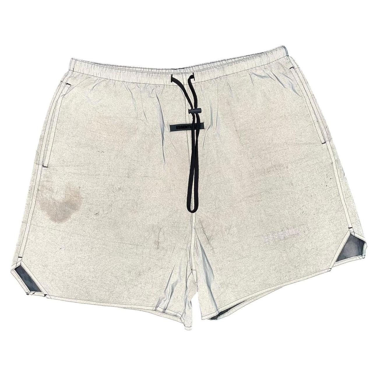 Essentials silver reflective nylon shorts with logo detail and sleek design.