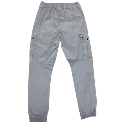 Stone Island blue cargo trousers with logo patch and RE-T fit, visible stain on left leg.