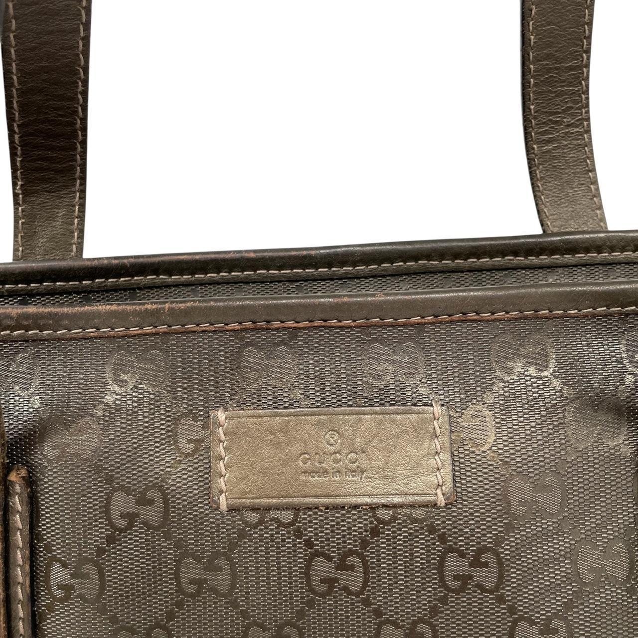 Gucci khaki green duffel bag with metallic monogram canvas and leather trim details.