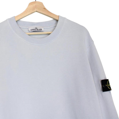 Stone Island blue cotton sweatshirt with logo patch and faded left sleeve.