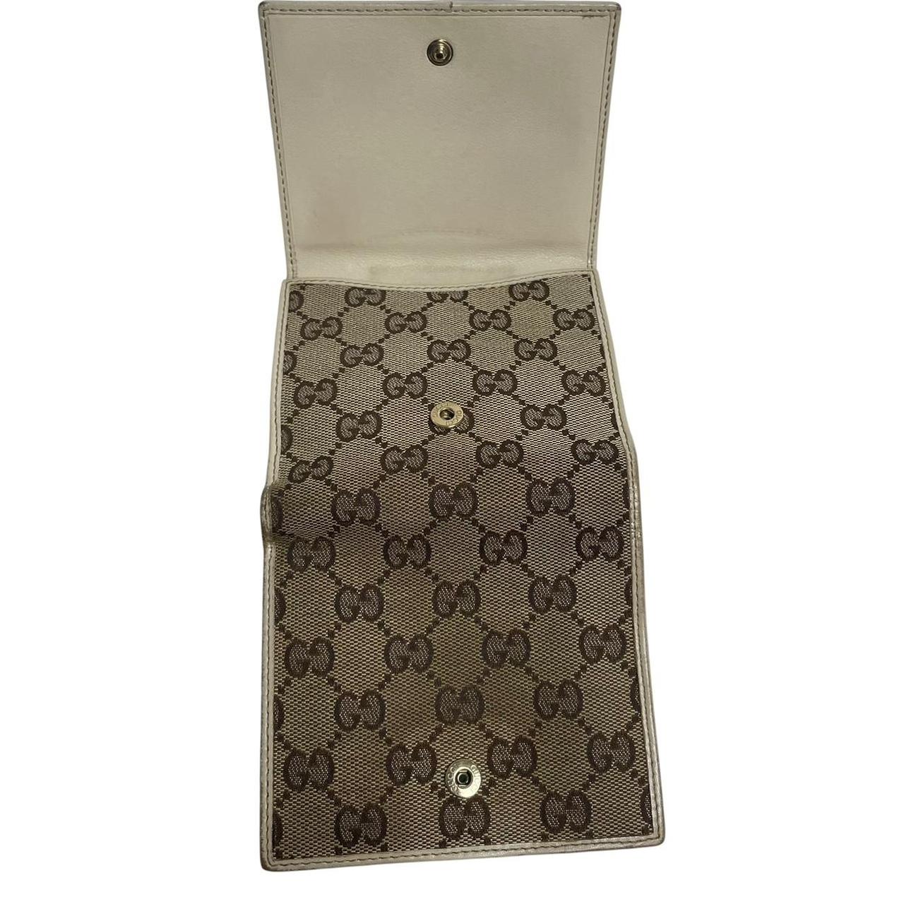 Gucci brown bifold wallet with Supreme monogram pattern and leather accents.