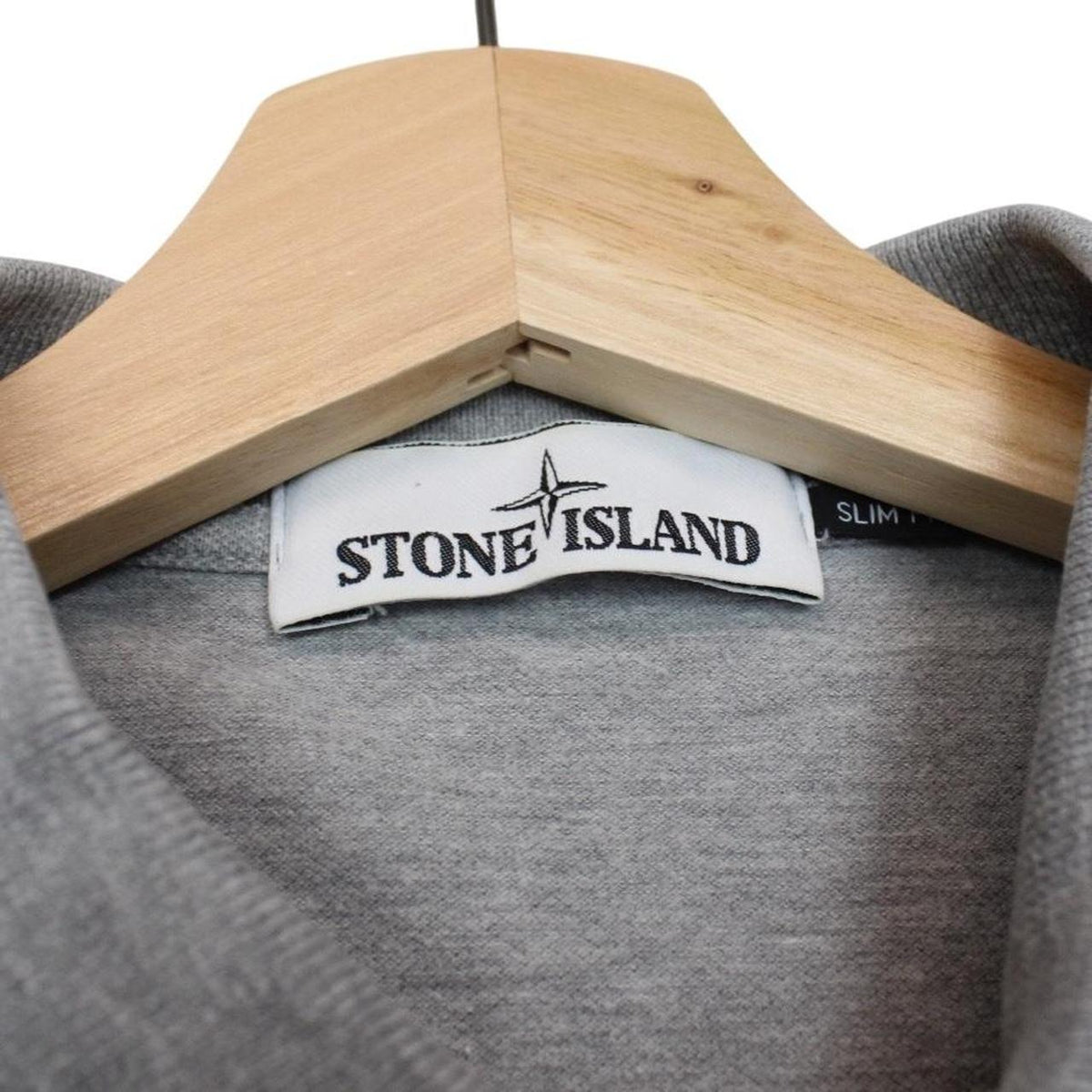 Stone Island grey polo shirt with embroidered compass logo and cotton material.