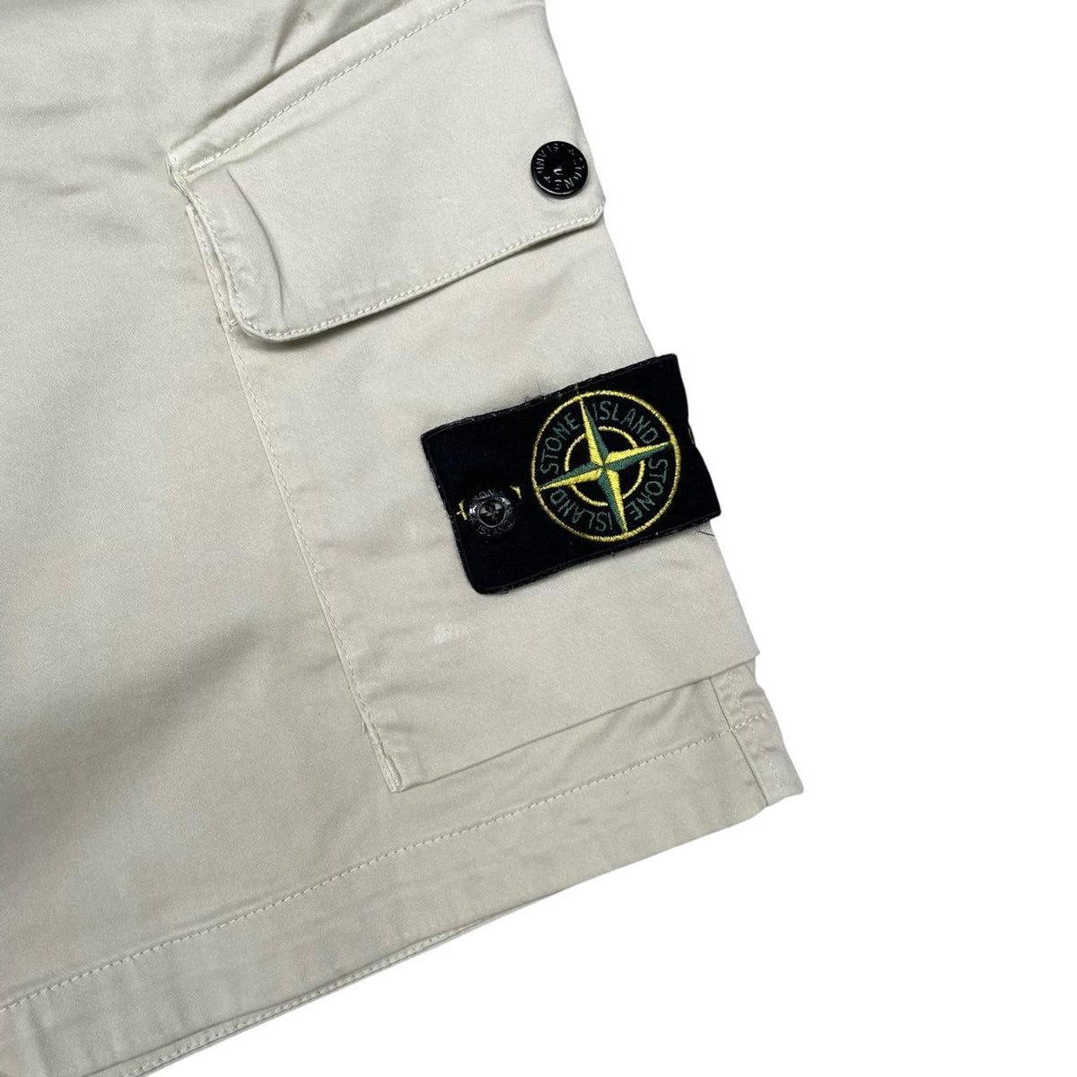 Stone Island beige cargo shorts with logo patch and multiple pockets.