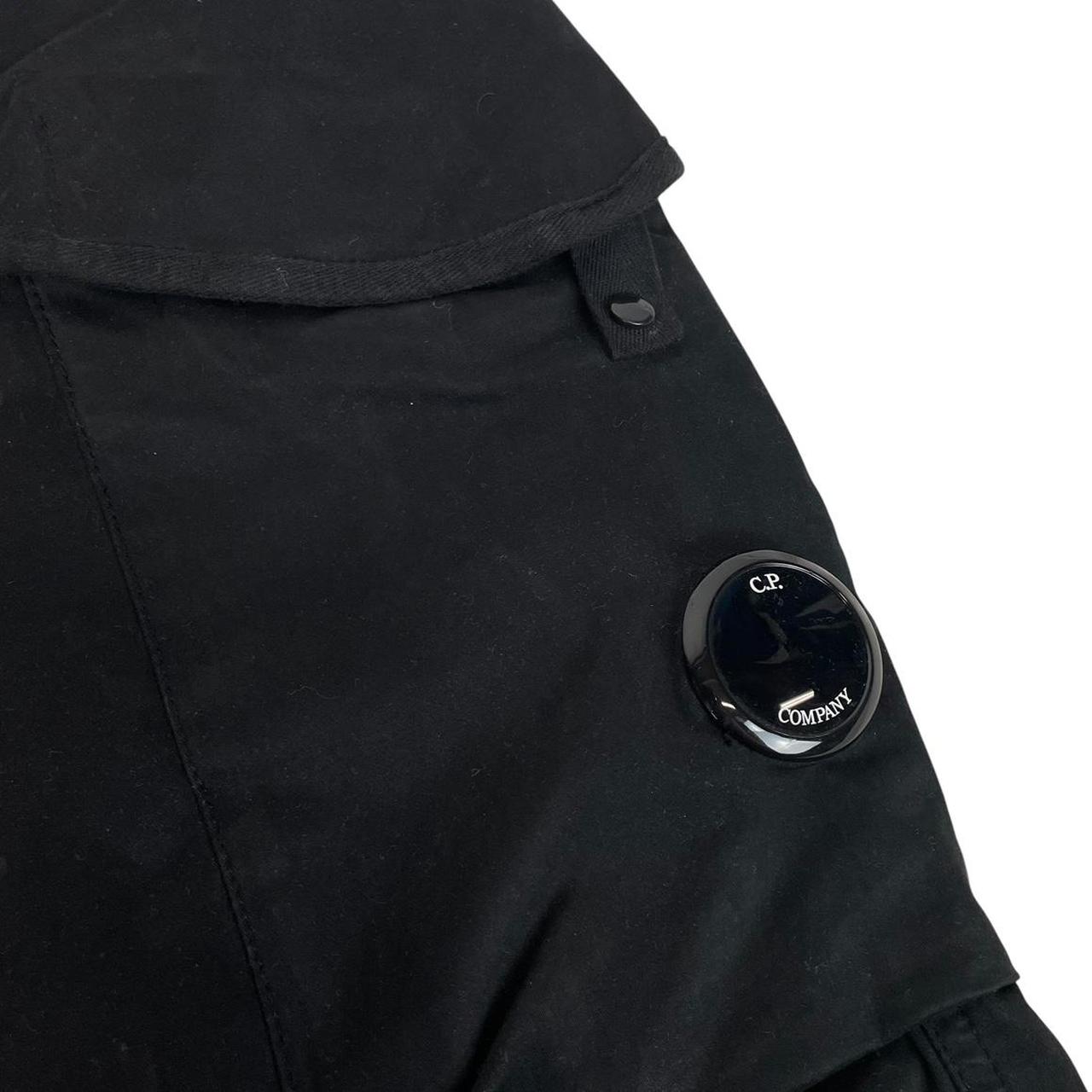 CP Company navy blue tapered fit cargo trousers with lens detail and pockets.